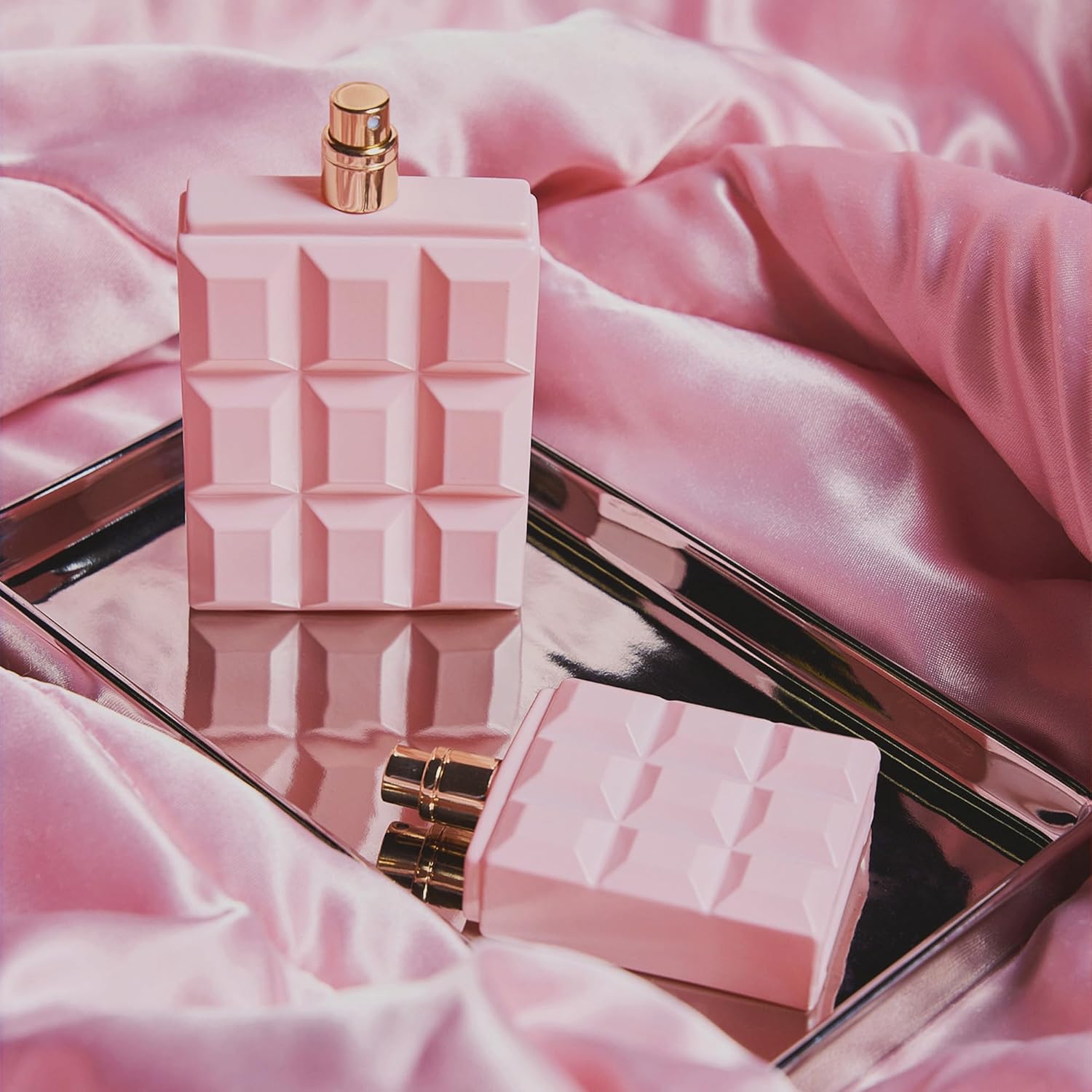 Helia άρωμα κομψότητα σε ροζ φιαλίδιο, τοποθετημένο πάνω σε ασημένια πλάκα με ροζ βελούδινο ύφασμα.