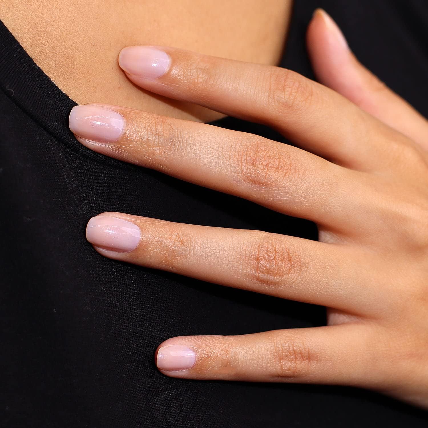 Helia concealer λάμψης applied on model's hand, showcasing natural, glowing skin with a subtle finish.